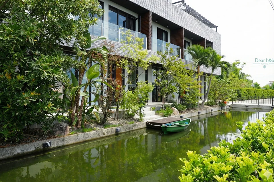 小島天光民宿：生態池裡的小船與房子倒影
