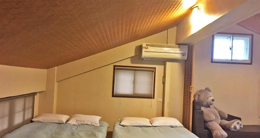 稻哪趣包棟民宿｜斜屋頂下的床鋪