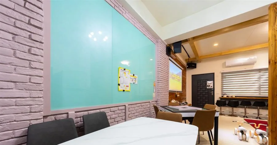 QK民宿卡弧灣二館｜粉色磚牆旁的用餐區