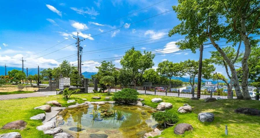 簡單緩慢渡假民宿｜草地庭院中的造景池塘